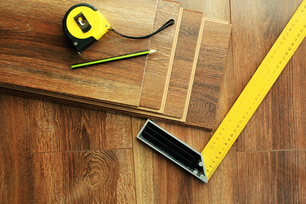Laminate floor planks and tools on wooden | Carpeteria